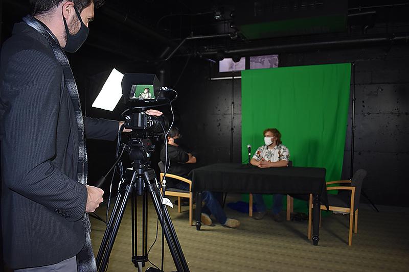 两名学生在电视演播室与教员Gyuri Kepes一起制作视频项目